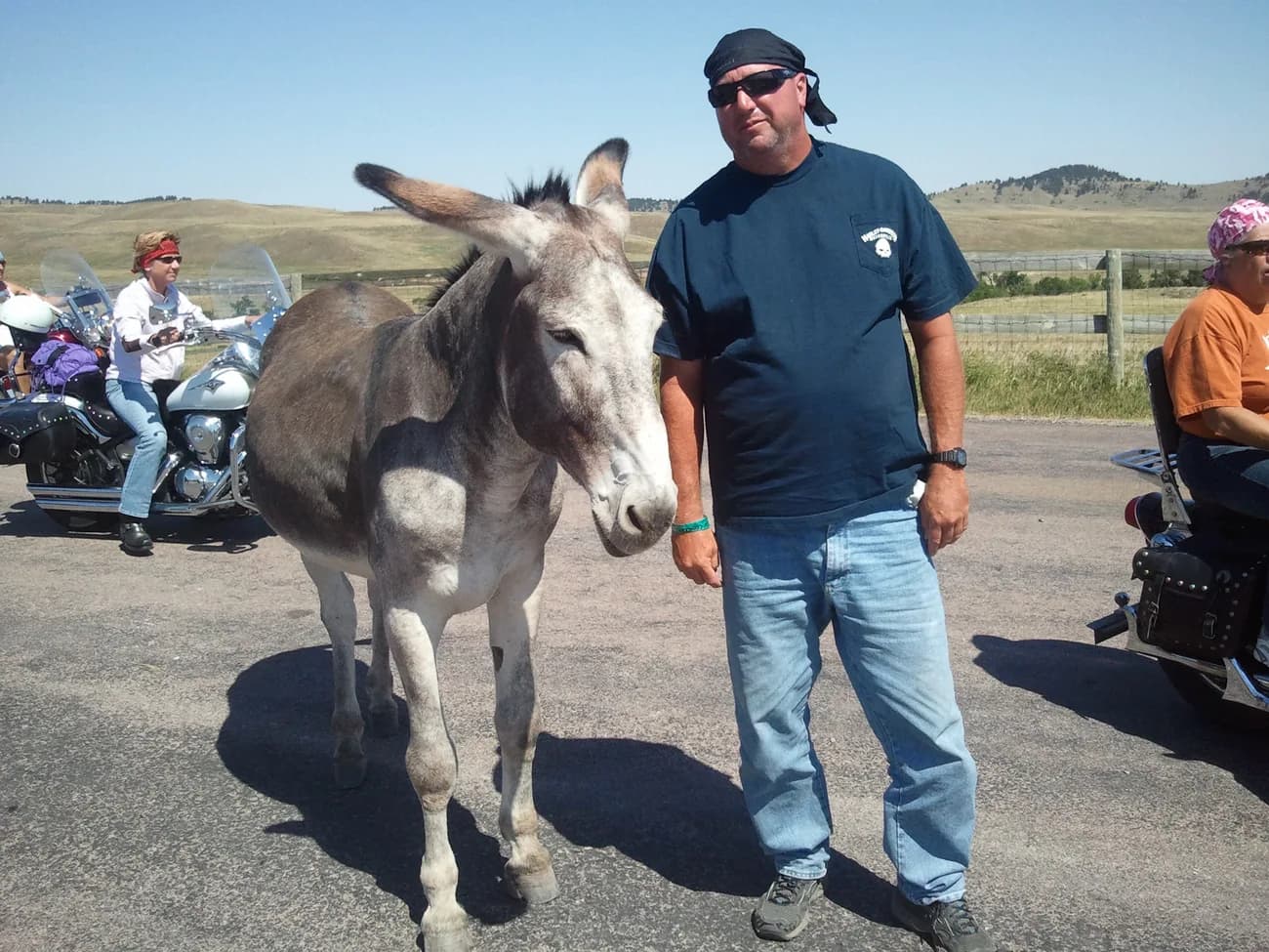 Michael standing beside a donkey on a roadside in the Black Hills